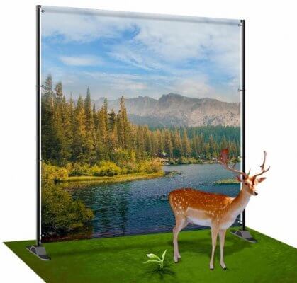 Cut-out deer on a green grass carpet with a river and mountain backdrop that was eco-printed!